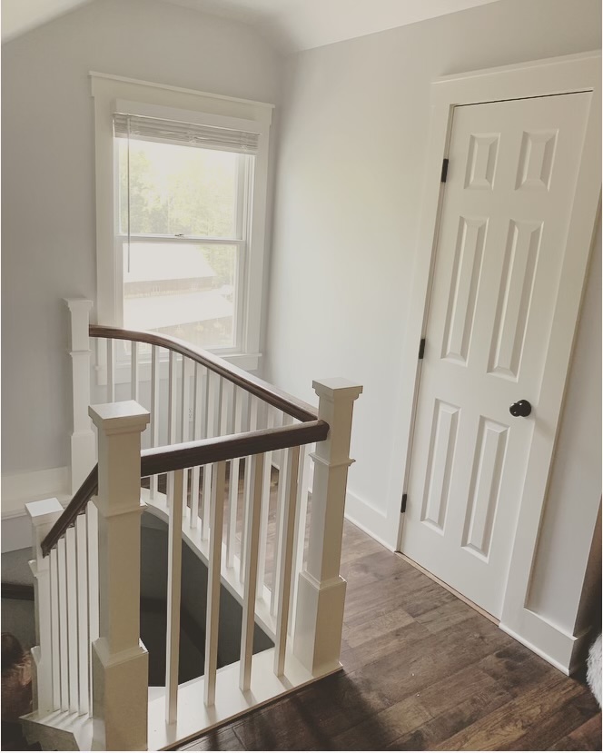 Attic top of winding staircase and bathroom door with window