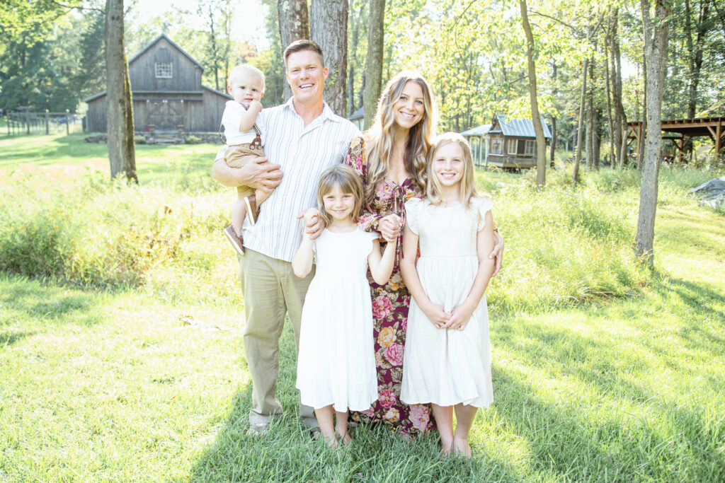 Family in front of barn, chicken coop Fern Acres