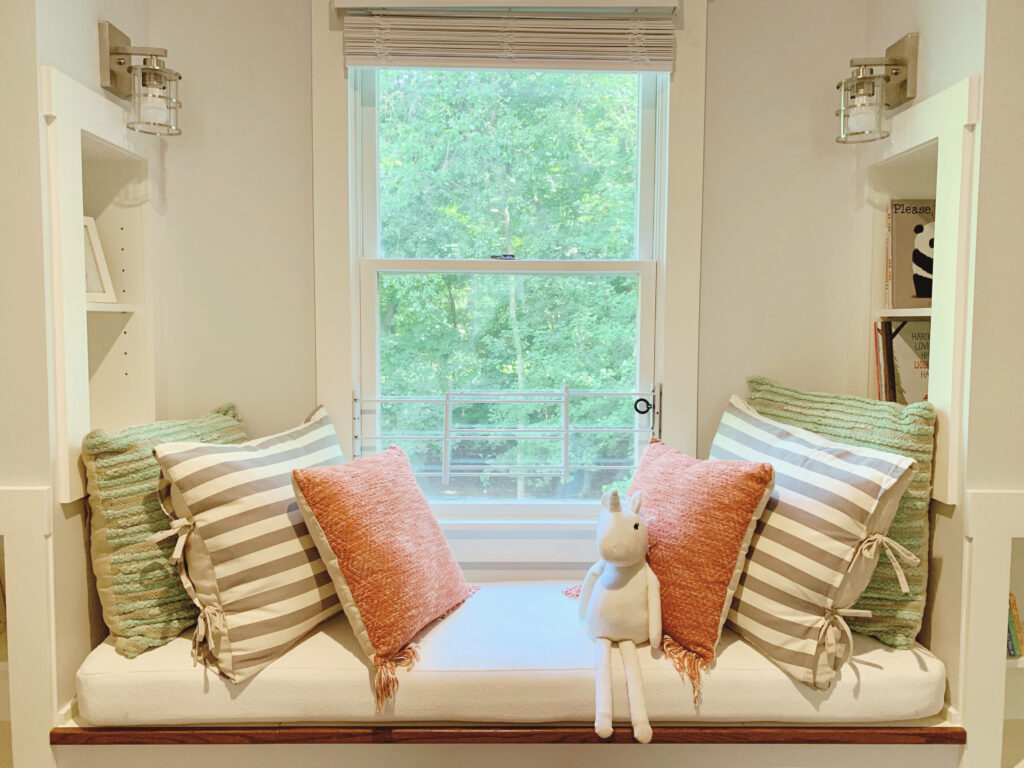 Attic window seat with pillows and other decor