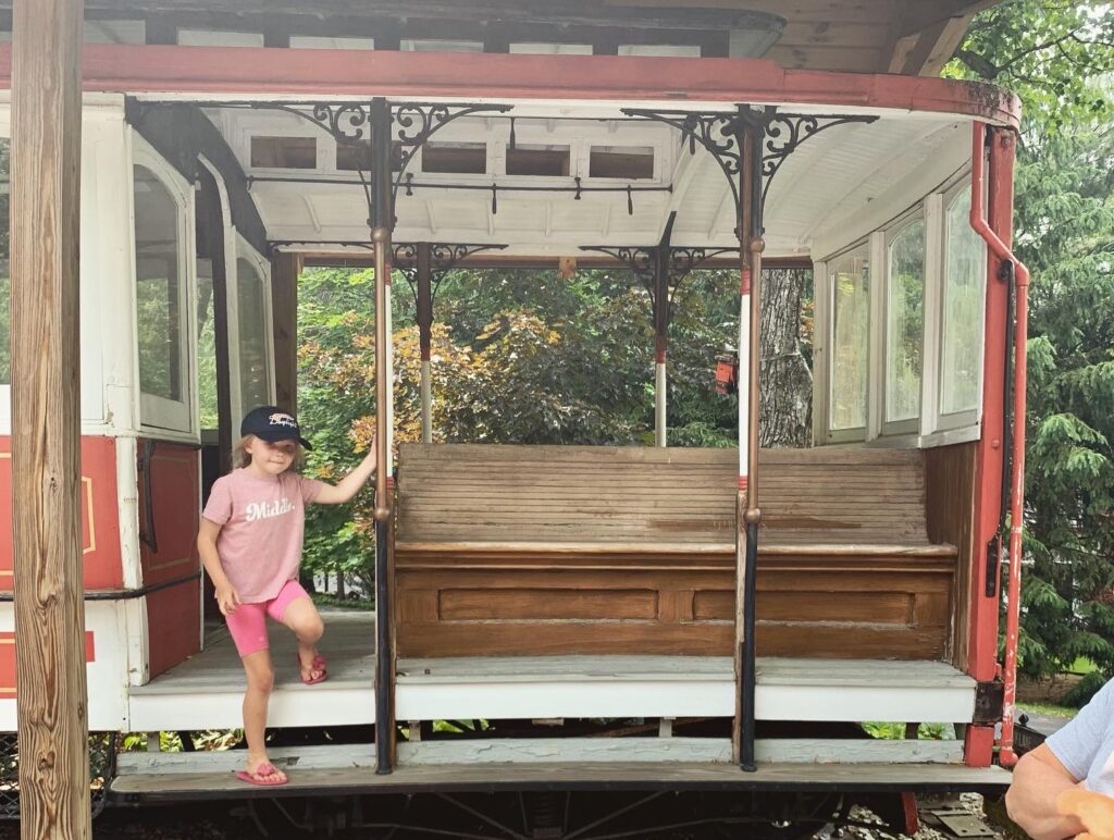 Little girl stepping off of vintage train