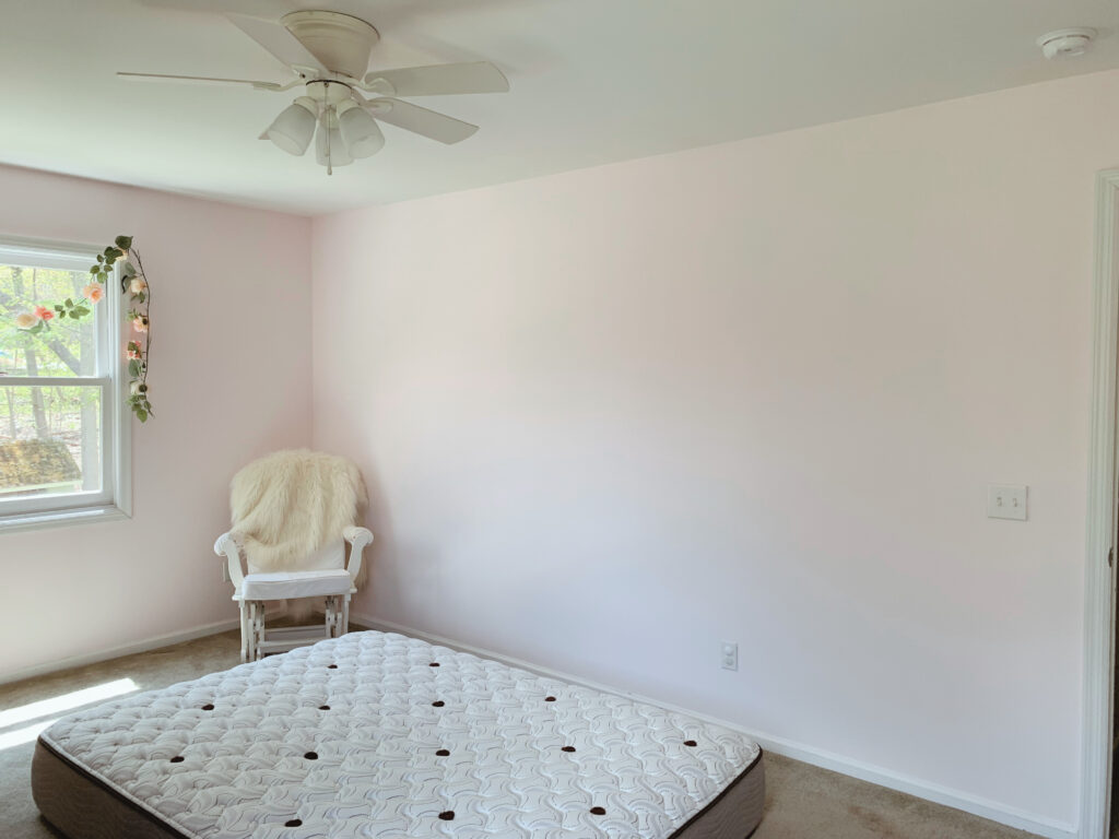 Freshly painted pink wall in bedroom refresh with blank wall