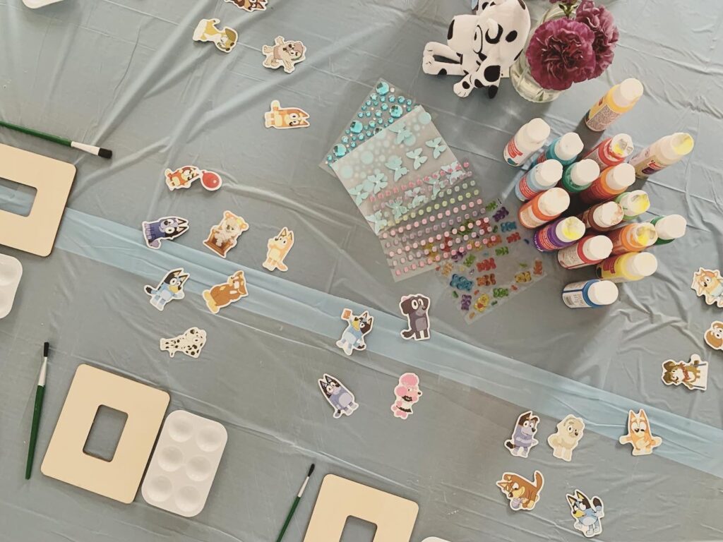 Bluey party craft table with unfinished wooden frames and paint