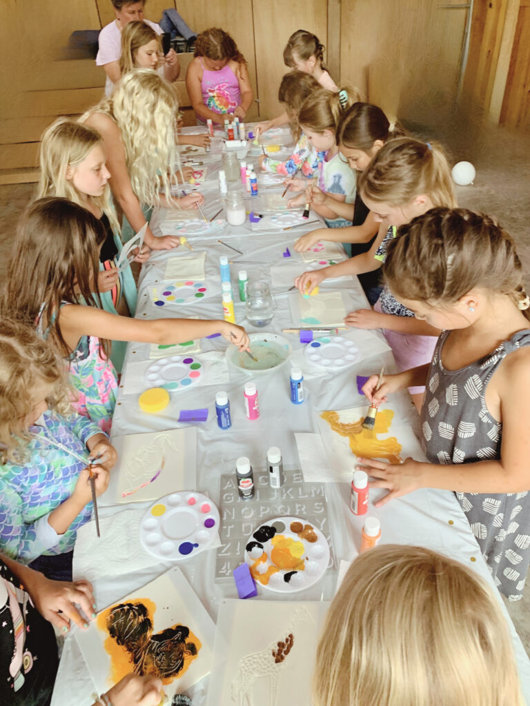 Kids painting at craft table at panda party