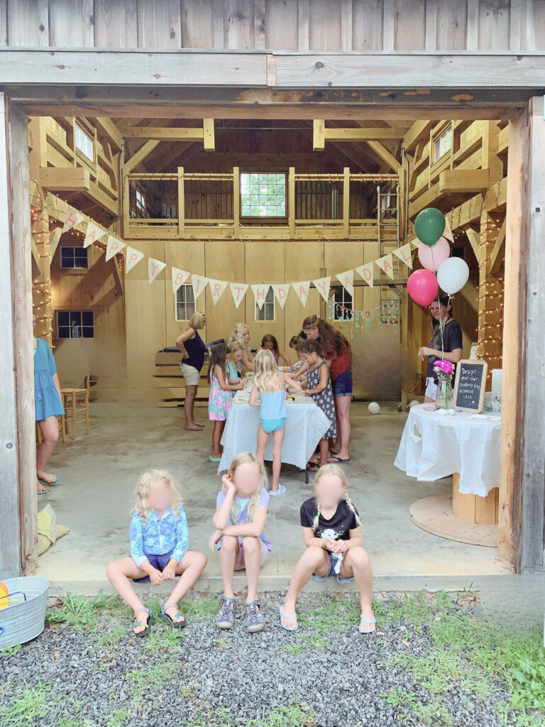 Kids sitting outside of barn craft area 