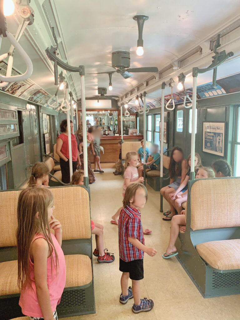 Kids sitting inside of an old subway car