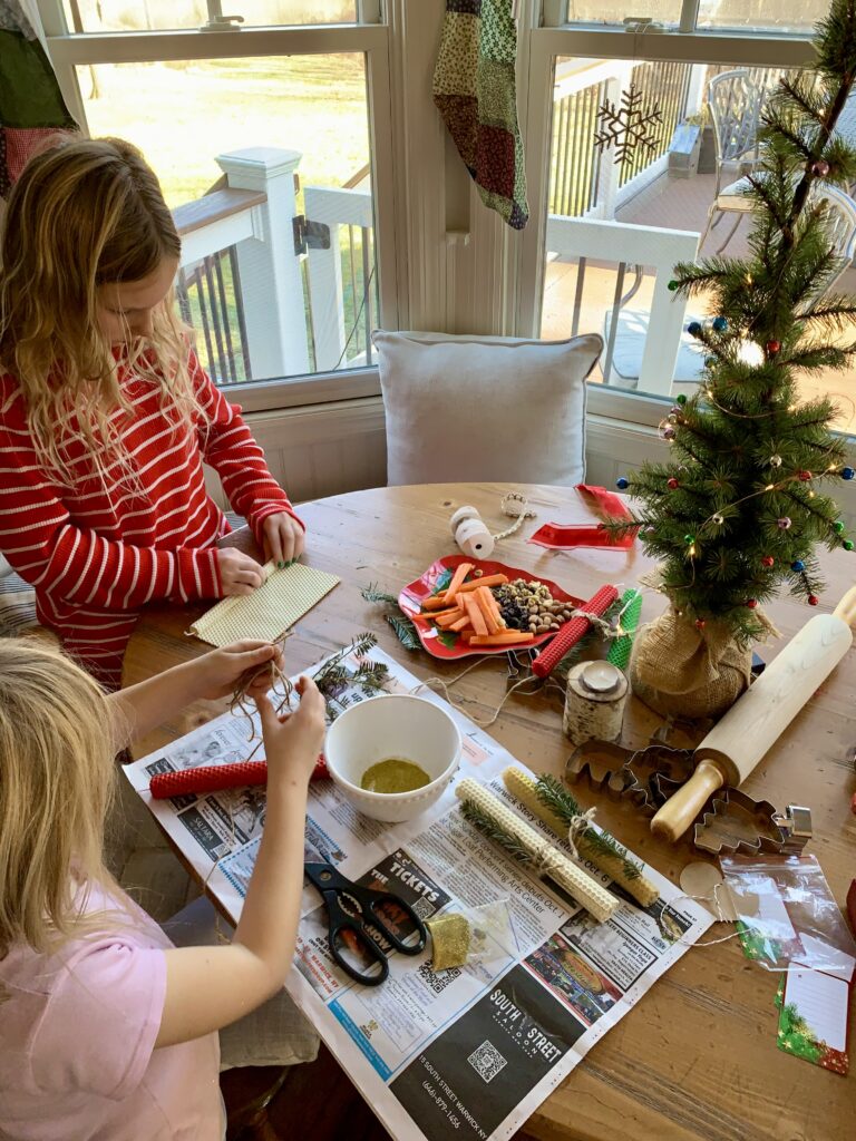 joy-filled Christmas girls making candles on table holiday decor and crafts