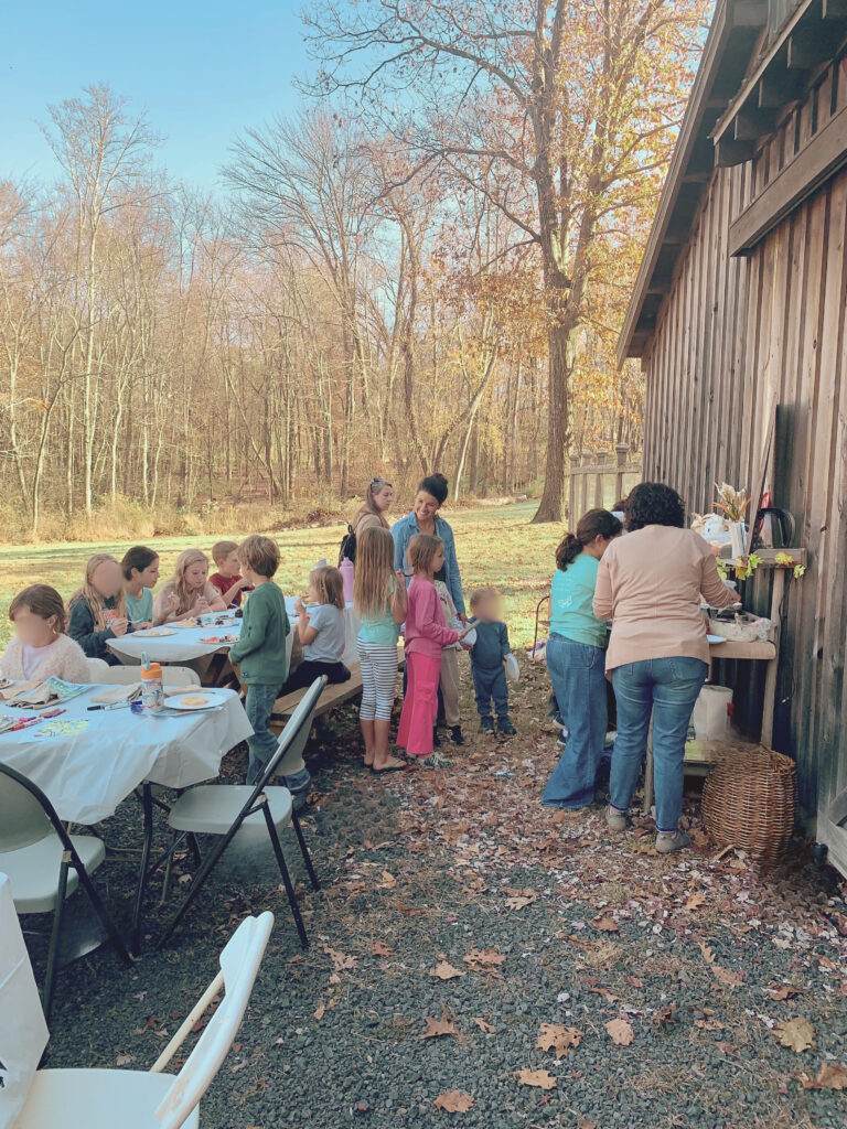 Children and adults behind barn setup for book discussion