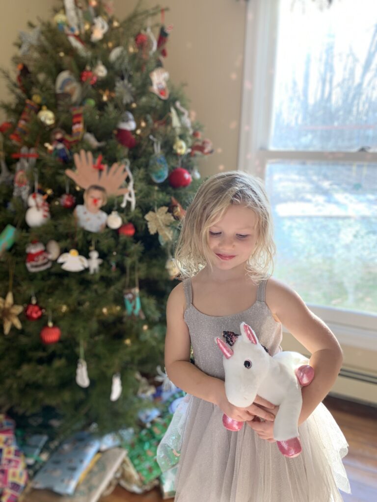 little girl Christmas tree with unicorn