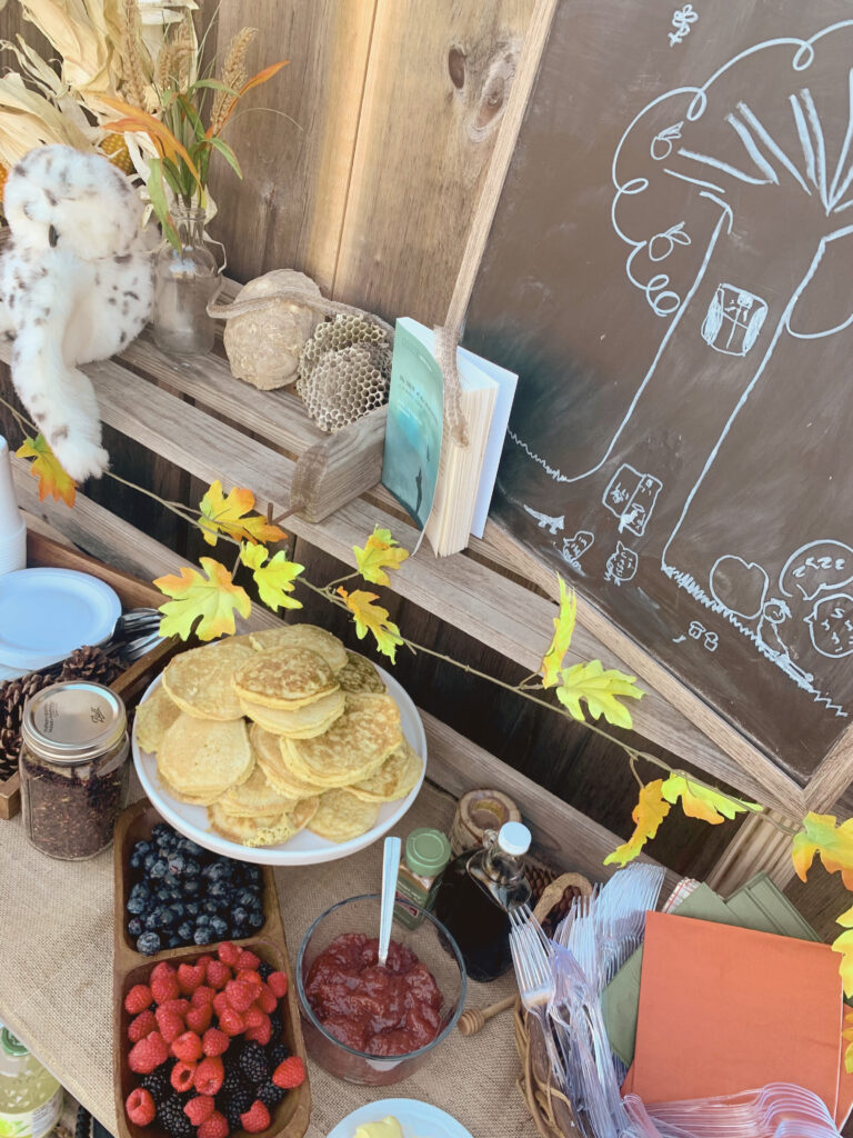 Book club food table with pancakes, jam, fresh berries, napkins, utensils