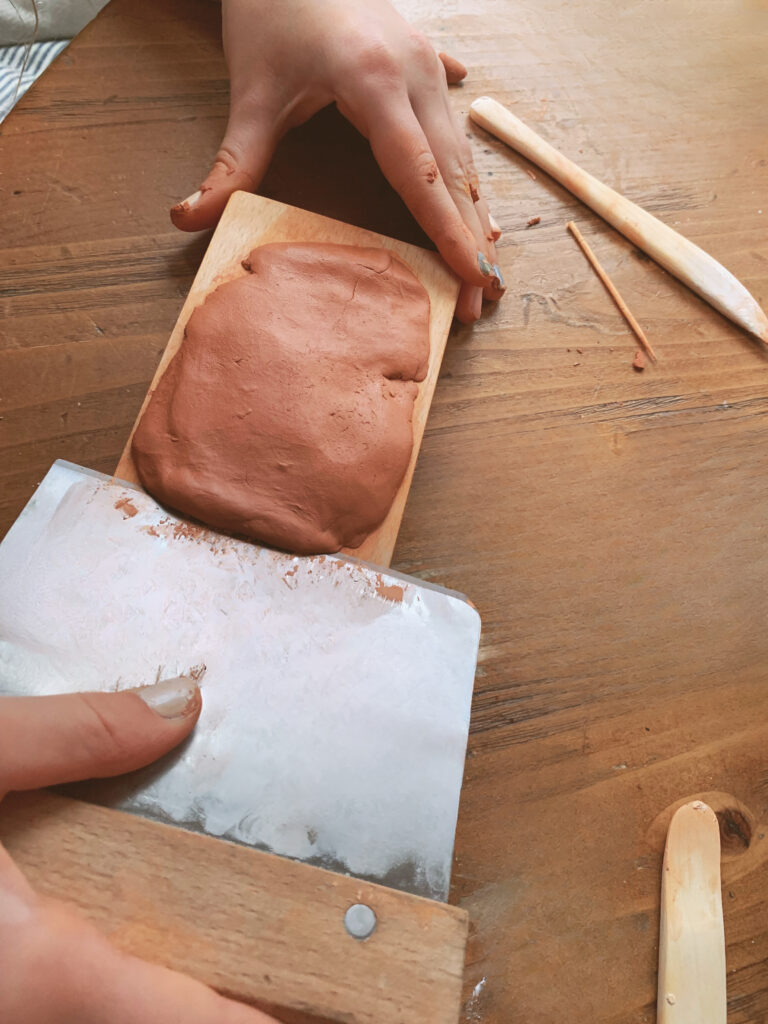 scraping excess terra cotta clay off mold