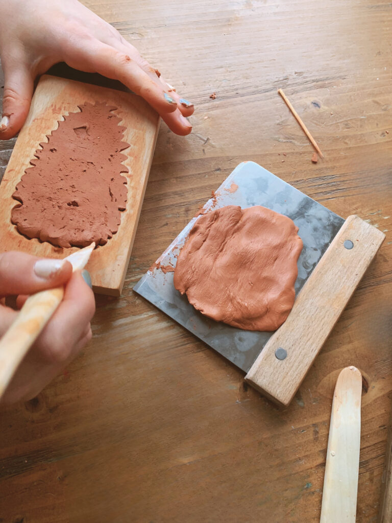 removing clay from mold with fingers and pottery tool