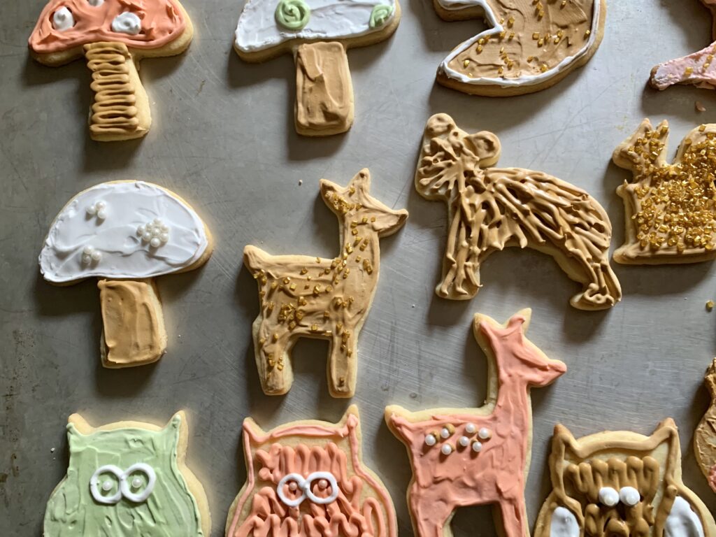 sugar cookies of woodland animals with icing on baking sheet