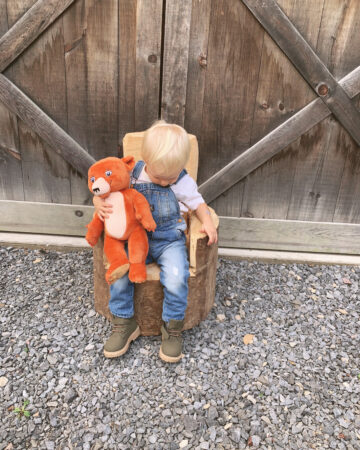 little boy sitting on stump chair